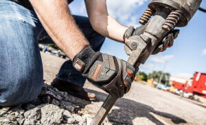Worker wearing anti-vibration gloves while drilling, reducing the risk of vibration-related injuries and hand-arm vibration syndrome.
