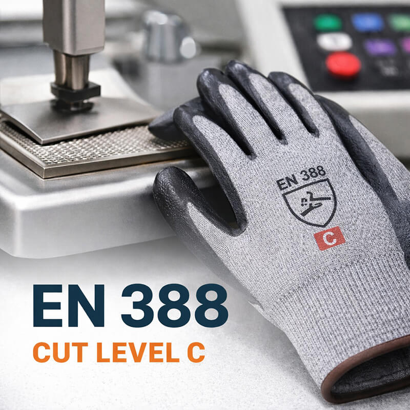Close-up of a gray nitrile-coated cut-resistant glove showing EN 388 standard with letter cut level C, placed on a cut resistance testing machine.